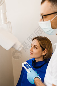 牙医为牙科女性进行 X 光牙齿扫描 用于检测牙痛和治疗牙根的牙齿 X 射线扫描卫生矫正诊所医院全景放射科x光考试口服x射线图片
