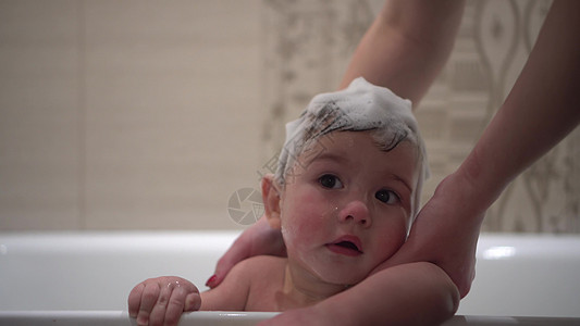一个男孩在浴室洗浴时头上沾着泡沫 头部被涂上泡沫 笑声卫生游泳飞溅乐趣身体眼睛洗发水微笑母亲肥皂图片