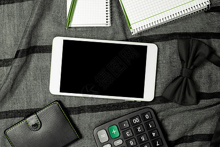 有重要消息的手机在有笔记本和计算器的织物上 有重要信息的智能手机在有时钟的表上 已提交延迟更新日记技术电脑男人商务创造力桌子衣服图片