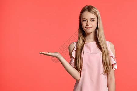 演播室肖像 一个美丽的女孩金发少女 穿着玫瑰色的T恤 在粉红色的背景大学女性教育头发学生孩子姿势金发女郎青少年成人图片
