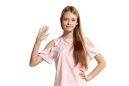 一个穿着粉红色T恤的漂亮金发女孩 穿着白色外衣被孤立在白背景上的片场肖像学生头发女性工作室大学教育青少年孩子潮人成人图片