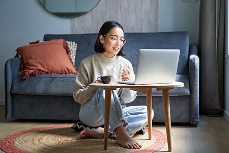 美丽的年轻女性专业人员的肖像 在离家很远的地方工作 与她的笔记本电脑 视频聊天 喝咖啡自由共舞图片