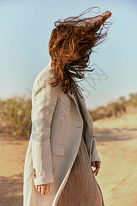 穿着轻衣的女人的肖像 头发从风中遮住她的脸图片