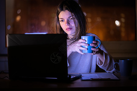 女人晚上在网上用笔记本电脑工作图片