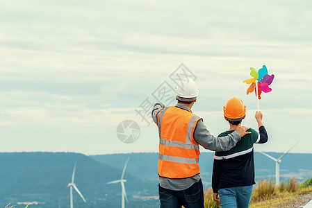 进化工程师和他的儿子 在山上拿着风车玩具呢农场工程涡轮工作场地绿地环境风力天空发电机图片