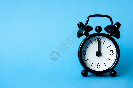 黑色闹钟在蓝背景上被隔离 时钟设定在下午12 00 复制空间和时间概念图片