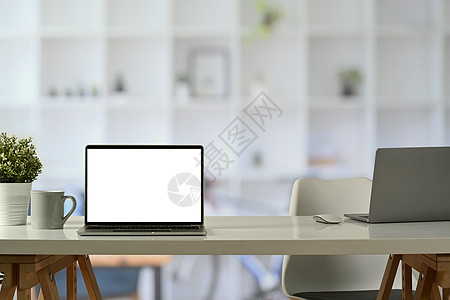 白色办公桌台的笔记本电脑前视 咖啡杯和陶瓷厂 广告设计空白屏屏障图片