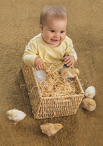 小宝宝坐在一个有小鸡的平方篮子里图片