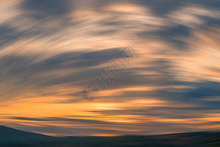 日落的山峰圆形运动背景模糊 橙色线阴影云层天空图片