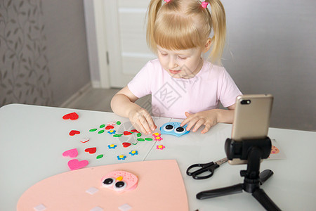 一位博客女孩以心灵的形状为情人节做了一种自觉的手工艺 儿童创造力和手工创作的概念 但是庆典学校剪刀孩子卡片博主假期孩子们爱好工艺图片