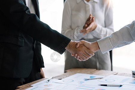 成功的谈判和握手理念 两位商务人士与合作伙伴握手庆祝合作和团队合作 商业交易基准营销电脑商务讨论金融投资战略同事图表图片