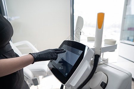 医生美容学家使用触摸屏对光复发装置进行调整 以适应感应屏护士药品身体技术女性温泉沙龙服务专家工具图片
