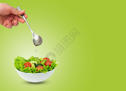 沙拉碗和雄手倒满油的加汤匙 沙拉与世隔绝黄瓜男性午餐厨师营养蔬菜菜单饮食广告勺子图片