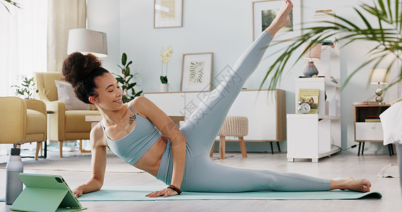 女性 平板电脑和瑜伽直播课程 用于在家庭客厅 家庭封锁和隔离中放松锻炼 锻炼和训练 采用普拉提技术的禅宗 伸展运动和健康瑜伽士房图片