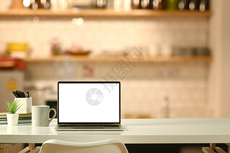现代的膝上型电脑白色桌子 有软和温暖的灯光 您的广告设计复制空间和空白屏幕图片