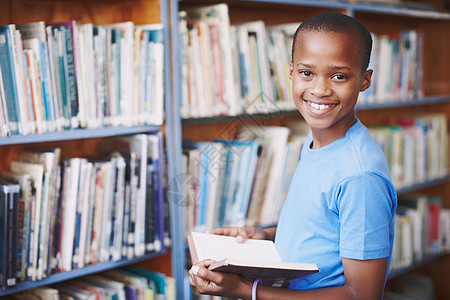 故事就像新的游乐场 一个非裔美国男孩的肖像在图书馆享受一本好书 (笑声)图片