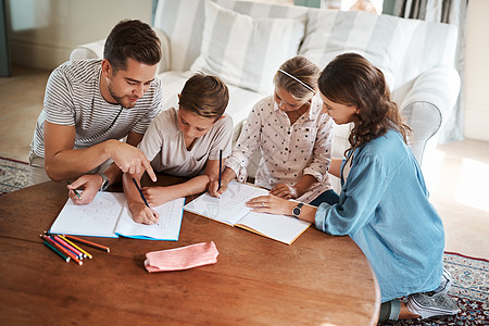 没有什么比支持家庭更能鼓励学习了 一个幸福的年轻四口之家一起做作业图片