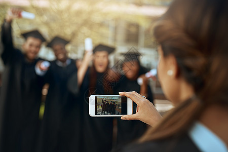 这是一个值得永远铭记的日子 一群学生在毕业那天用手机拍照图片