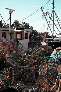 在港口码头 近身底底底鱼网和渔船上堆叠的渔网蓝色齿轮食物陷阱渔业漂浮浮标绳索钓鱼渔夫图片