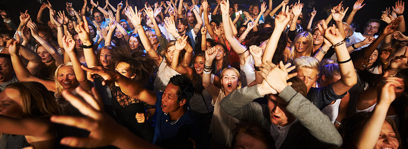 在摇滚音乐会 现场乐队表演或音乐节上与人群一起进行音乐 舞蹈和派对 新年 活力和迪斯科 粉丝们在庆祝技术 狂欢或夜总会活动时聆听图片
