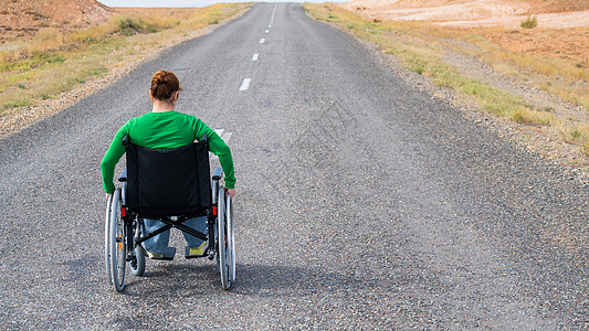 草原上的路在草原上的高速公路上坐轮椅的女人驾驶女士运输援助农业动机草地土地速度国家背景