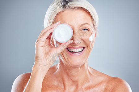 美容 护肤和高级女性 在灰色工作室背景下使用保湿面霜 微笑 模特和女性 使用面霜 乳液或化妆品 以保持皮肤健康或抗衰老图片