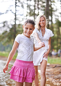妈妈 一个可爱的小女孩 和她妈妈一起在荒野小溪里跑来跑去母亲孩子们森林乐趣孩子父母女士女性青年家庭图片
