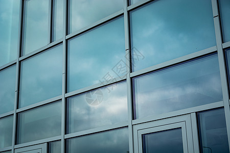 现代建筑表面的云层反射到一栋现代建筑的外表图片