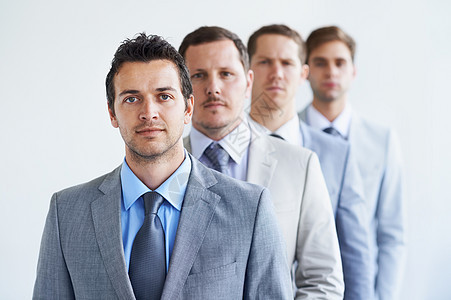 他们对成功并不陌生 一群认真的商务人士站在一排线上的肖像 (笑声)图片