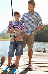 他学得很快 父亲和儿子 站在他们的钓竿旁图片