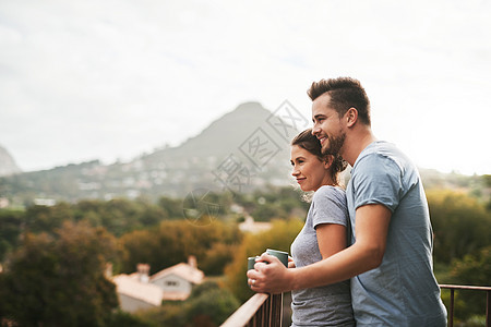 完美的视野与完美的陪伴 一对恩爱的年轻夫妇早上站在家里的阳台上喝咖啡图片