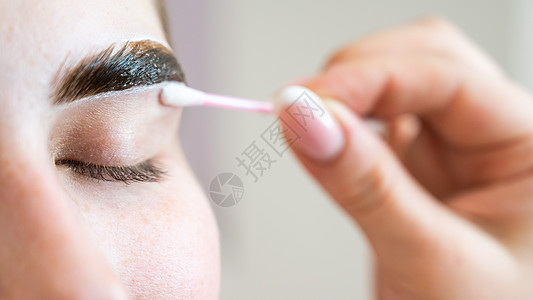 主人画了一个女人的眉毛眼皮采摘指甲花女性治疗乐器化妆师油漆梳理刷子特写高清图片素材