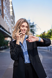 自信的女商务人士开会 站在街上 用手机聊天和在数字手表上查看时间的肖像商务电子商务职场电话代理人工作售货员女士套装人士图片