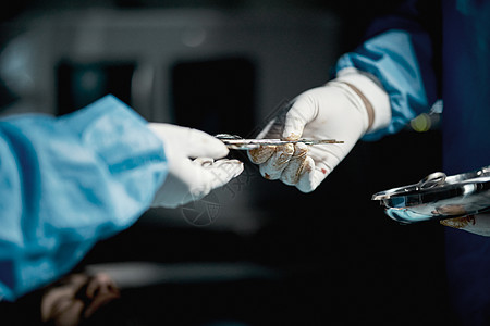 急救室 手术室或手术室手术用的外科医生 手和医用剪刀 医疗保健医院的医疗保健人员和医生团队使用钢制工具对患者进行手术背景图片