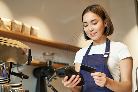 可爱的亚洲女孩 咖啡馆里的咖啡师处理非接触式支付 将信用卡插入 POS 终端 在咖啡店点菜工作职业餐厅店铺商业服务信用酒吧读者柜图片