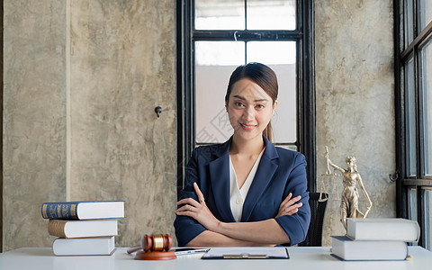 坐在办公室工作场所的笑着微笑的女律师肖像合同管理人员职业女士公司顾问人士权威法律法官图片