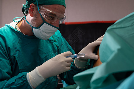 外科医生在手术前用消毒注射器向病人注射麻醉剂护士疾病情况药品团队保健医院程序操作助手图片