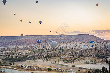 由土耳其卡帕多西亚上空飞来的多彩热气球日落太阳内夫热气球火鸡土地场景旅行砂岩地质学图片