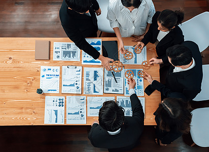 按和谐办公室办公桌上的商务人士群体分列的顶端手持设备最高档业务建设团体男人成功人士数据工作商务战略图片