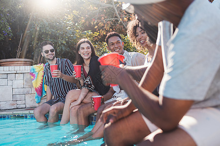 假期 饮料和朋友在夏季聚会 庆祝活动或家庭活动中的游泳池里讲话 多样性 快乐和人们交谈 在游泳池边喝酒时玩得开心和亲密图片