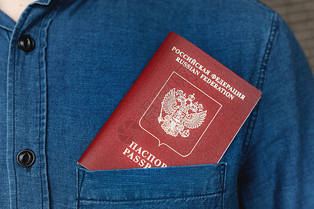 护照在牛仔衬衫口袋内 特写 外出旅行概念图片