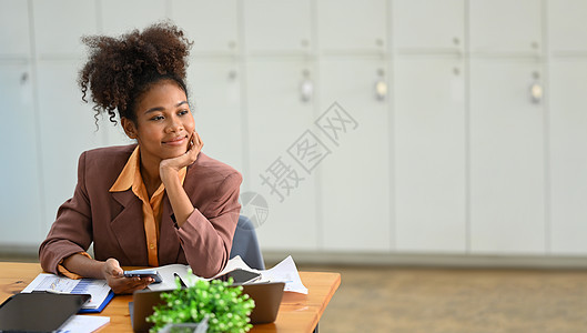 坐在工作场所 目视窗外思考投资战略或项目成功与否的平静女商业妇女坐着工作单位图片