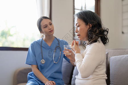 高龄妇女在照料者为她提供药物咨询时服药的内容 包括老年人用药 疗养院 家庭保健等内容第12条治疗护士男性处方女士护理帮助医院医生图片