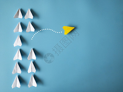 黄色纸飞机折纸将其他白色飞机留在蓝色背景上 并带有可定制的文本空间 领导技能概念图片