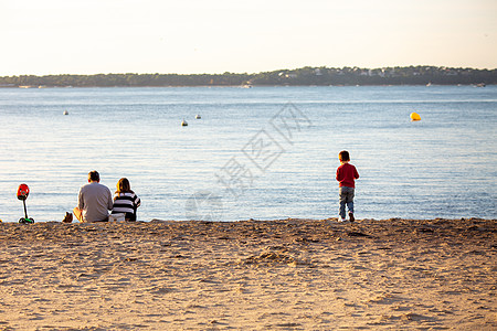 海滩上有小孩的年轻夫妇图片