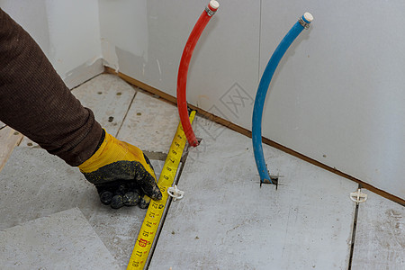 承包商准备通过在切割前测量陶瓷瓷砖铺设地板砖瓦图片