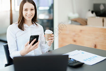 一个在电话上聊天和喝咖啡的女商务人士的肖像喜悦牙齿酒店咖啡杯阅读快乐咖啡店人士企业家商业图片