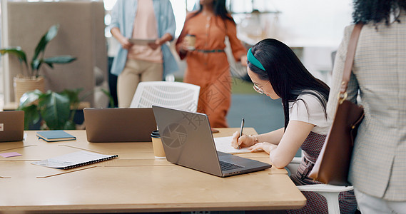 亚洲女性 笔记本电脑和在笔记本上书写 用于规划战略 日程管理或办公室财务清单 员工 阅读电子邮件通讯和创意创业公司的笔记工作人士背景图片