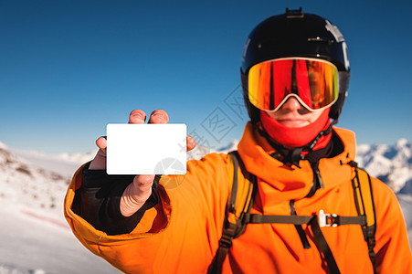 手持空白电梯口的滑雪机或滑雪机手持空帆票 背景有山峰肖像图片