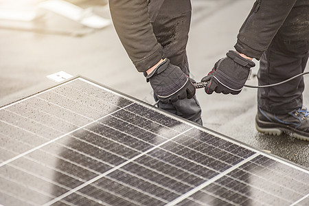 太阳能电池板安装人员使用电缆或插头线将模块连接在一起 在屋顶安装工作 将太阳能电池板连接到具有复制空间的电网图片